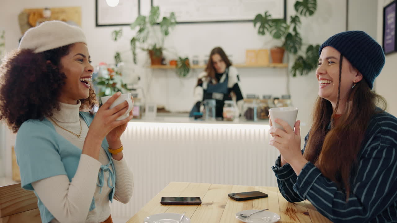 Two cheerful women enjoying coffees at a cafe