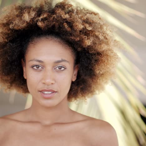 young woman against palm tree branch