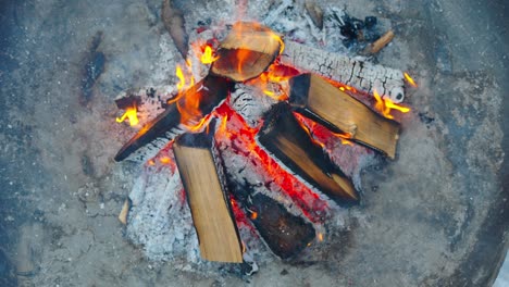 top down high angle close up of outdoor fire pit, flames and burning wood