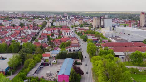 Volando-Hacia-Atrás-Con-Drones-Y-Filmando-Hiperlapso-En-El-Distrito-De-Brcko-De-La-Pequeña-Ciudad-En-Bosnia-Y-Hezegovinia,-Por-Encima-De-Automóviles,-Camiones-Y-Ferrocarril