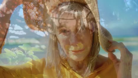 Composite-video-of-caucasian-senior-woman-wearing-a-hat-smiling-against-plants-in-the-garden