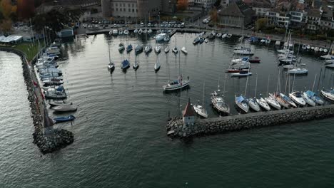 a wide shot of a single yacht is sailing into harbour following a yachting competition on lake geneva