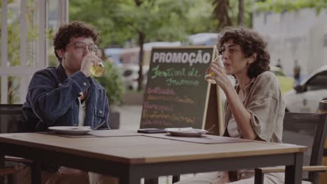 friends toasting and smiling at an outdoor cafe