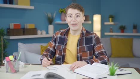 joven estudiante haciendo la tarea mira a la cámara con asombro.