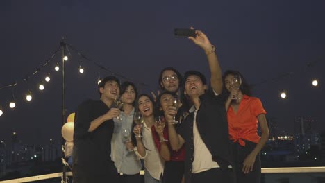 celebración de personas con amigos fiesta y fotografía selfie con teléfono inteligente juntos. concepto de festival, cumpleaños, feliz año nuevo y navidad. resolución 4k.