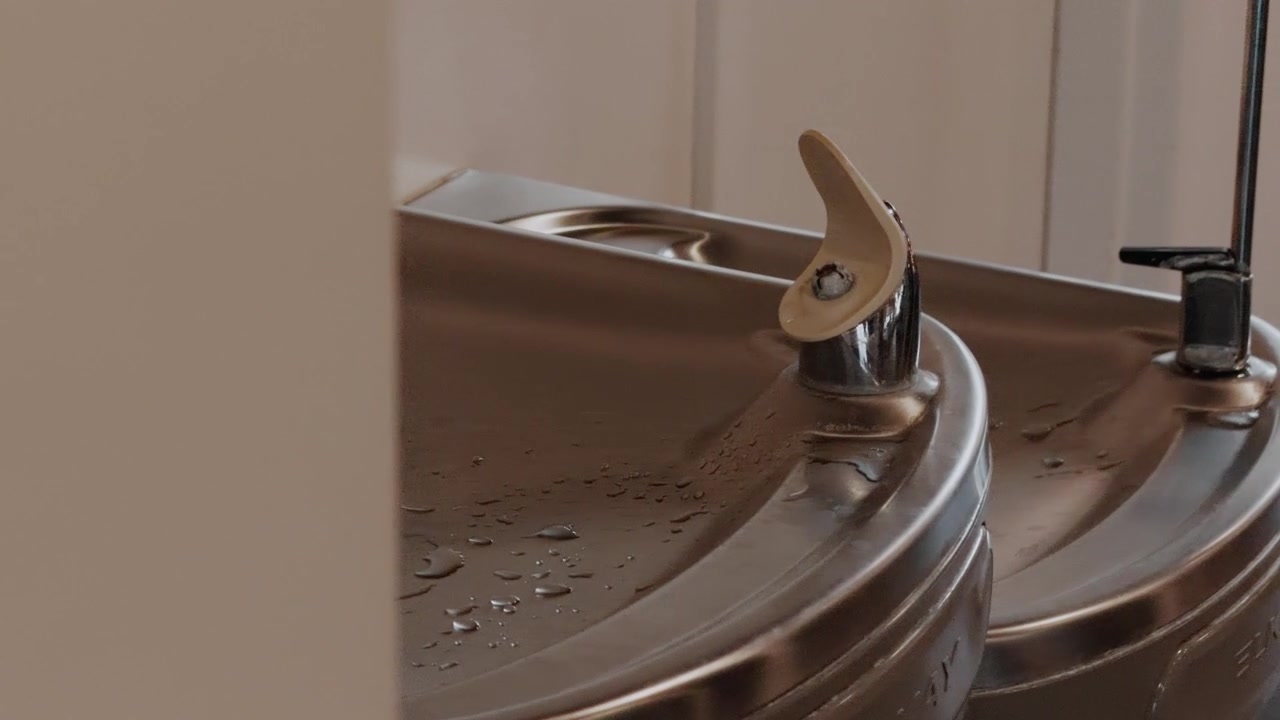 Slow left-to-right glide reveals a stainless steel drinking fountain.