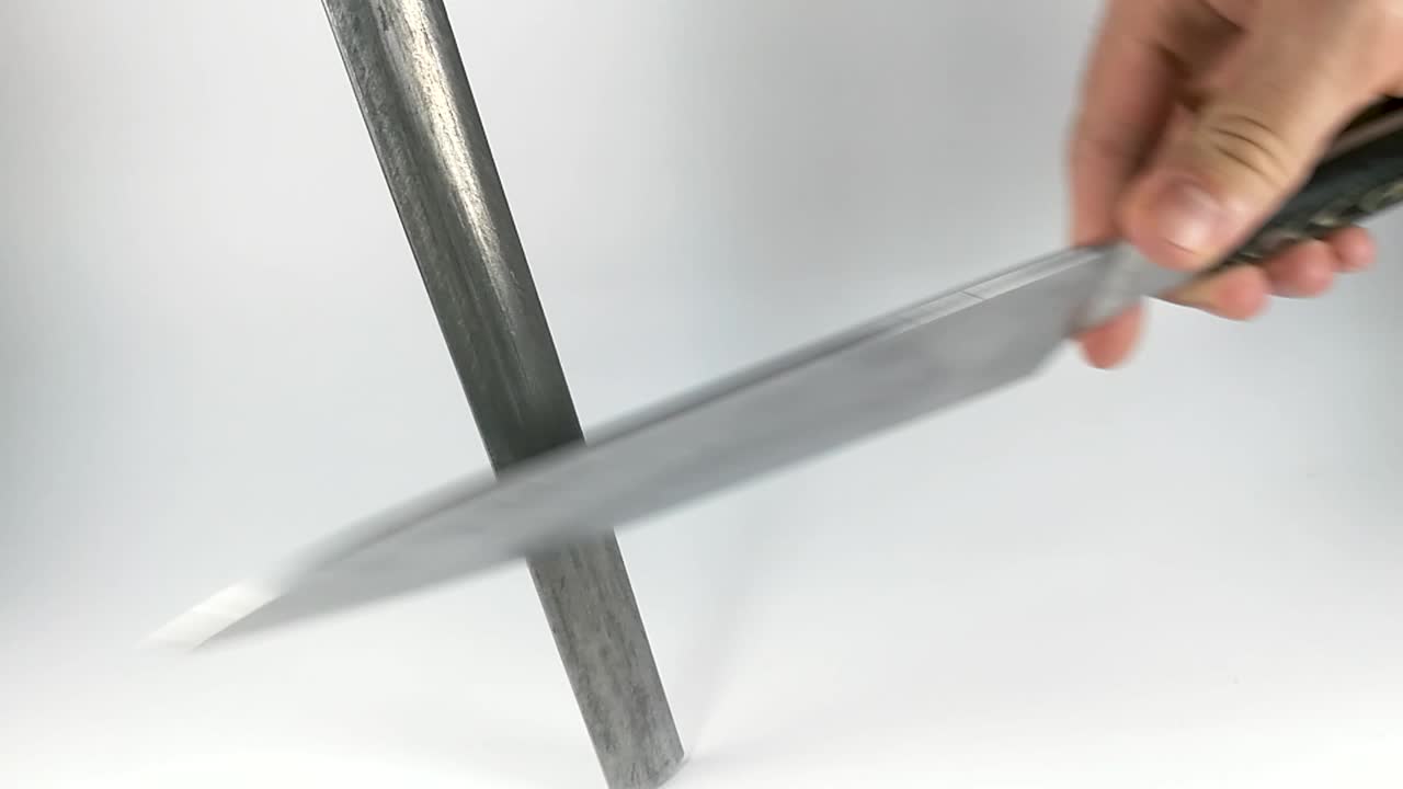 Male hand sharpening stainless steel Japanese knife, STILL, ISOLATED