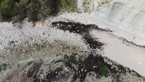 aerial birds eye view of rocky shorelines with vegetation along seaton undercliffs near lyme regis.