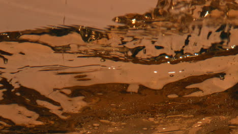 carbonated beer splashing goblet closeup. inebriant liquid overflowing glassware