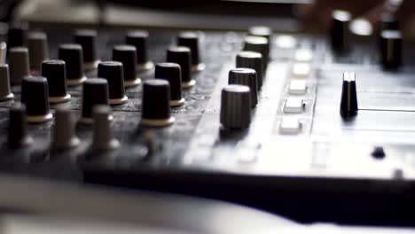 High-Definition-shot-of-DJ's-hand-next-to-spinning-vinyl-on-DJ-table