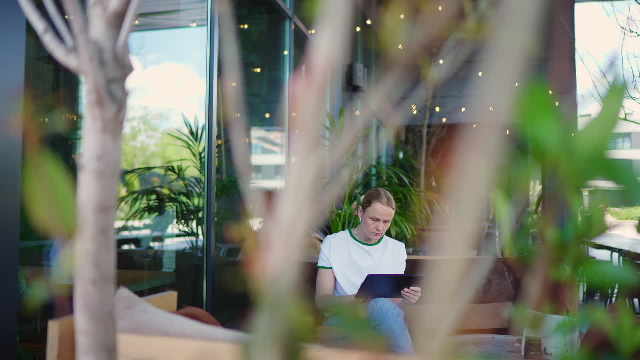 Giovane uomo che usa un tablet in un moderno caffè