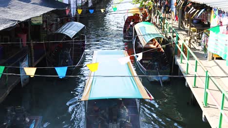 los barcos maniobran a través del bullicioso canal del mercado flotante.