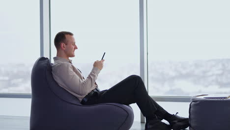 businessman relaxing in office with a smartphone