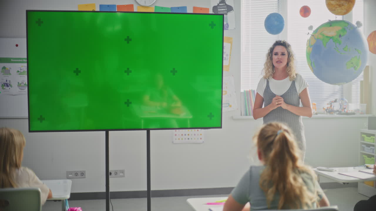 Female teacher with laptop teaches alphabet in online primary school class at home