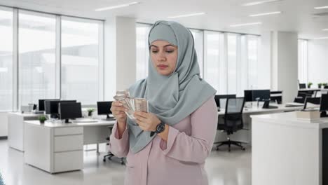 serious muslim businesswoman counting money