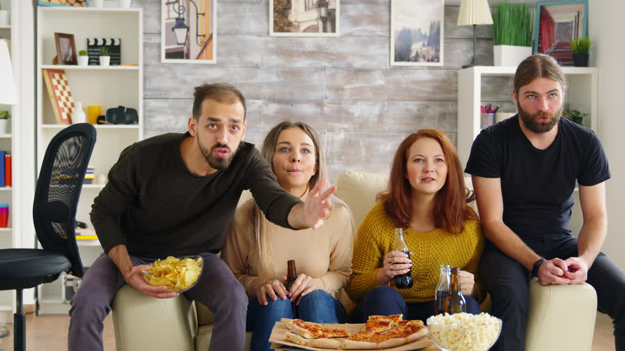 Amici intimi guardano la TV nel salotto