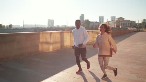 pareja joven corriendo juntos al aire libre