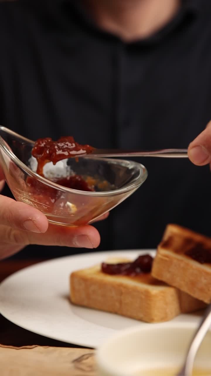 Close-up of Hands Spreading Jam on Toast for Breakfast