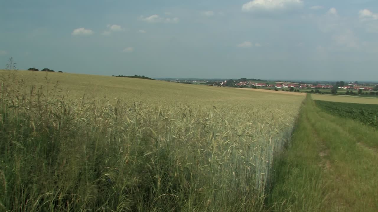 Pan shot across typical bavarian landscape with fields and village of Adelshausen in the back, Bavaria, Germany