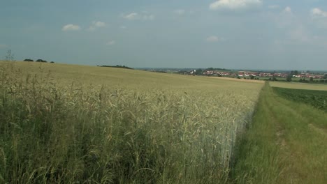 pan shot across typical bavarian landscape with fields and village of adelshausen in the back, bavaria, germany