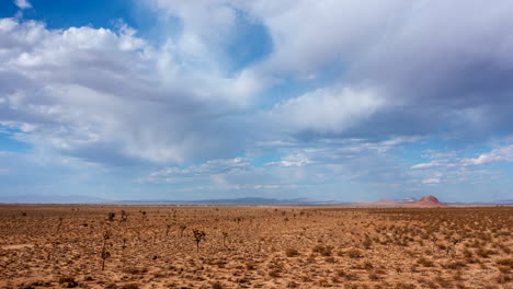 un hiperlapso aéreo en movimiento rápido sobre el desierto de mojave, árboles de joshua y una cuenca plana con montañas en la distancia