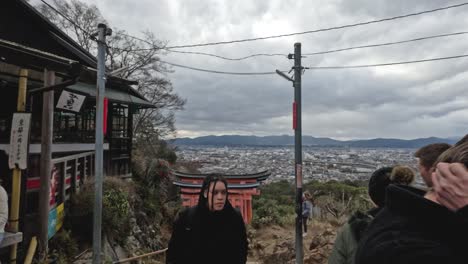 group of tourists visiting a historic shrine with city view