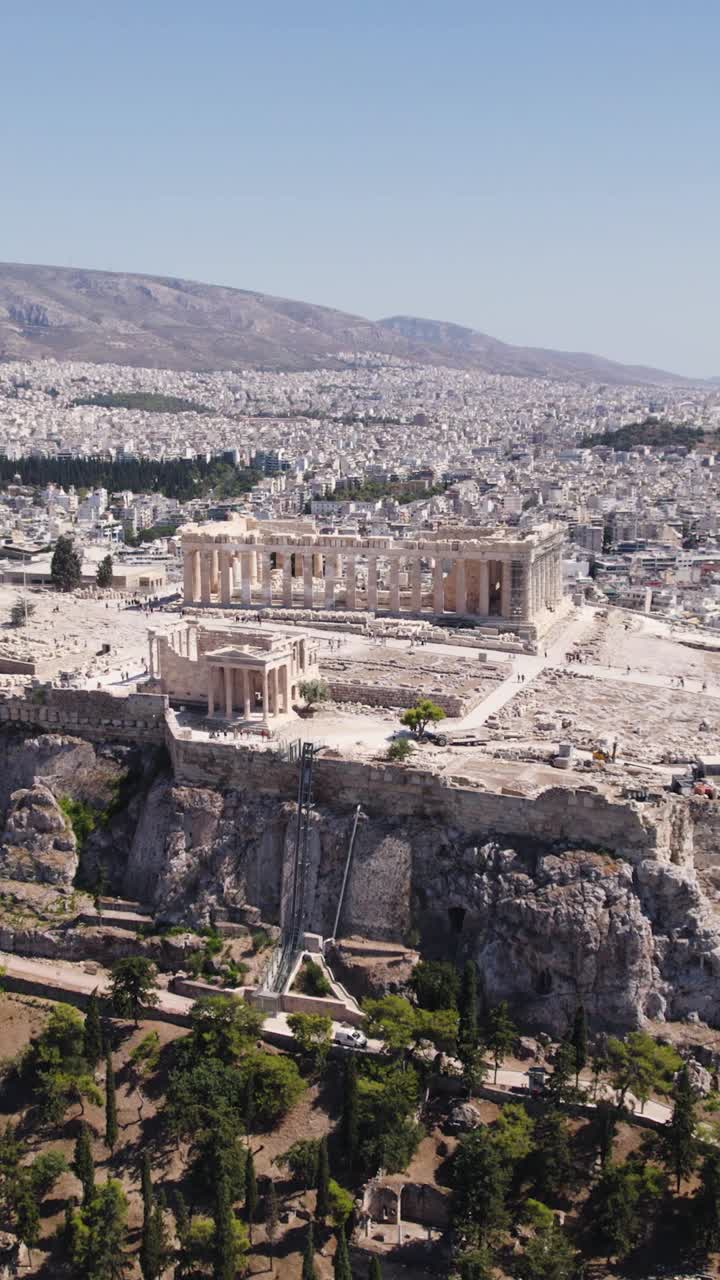 Vertical drone orbiting Athens’ majestic Acropolis with the vibrant cityscape in the background