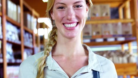 smiling female staff holding basket of bread at bread counter