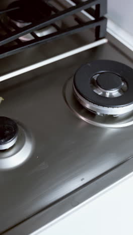 cleaning kitchen gas stove. womans hand cleaning gas stove with sponge
