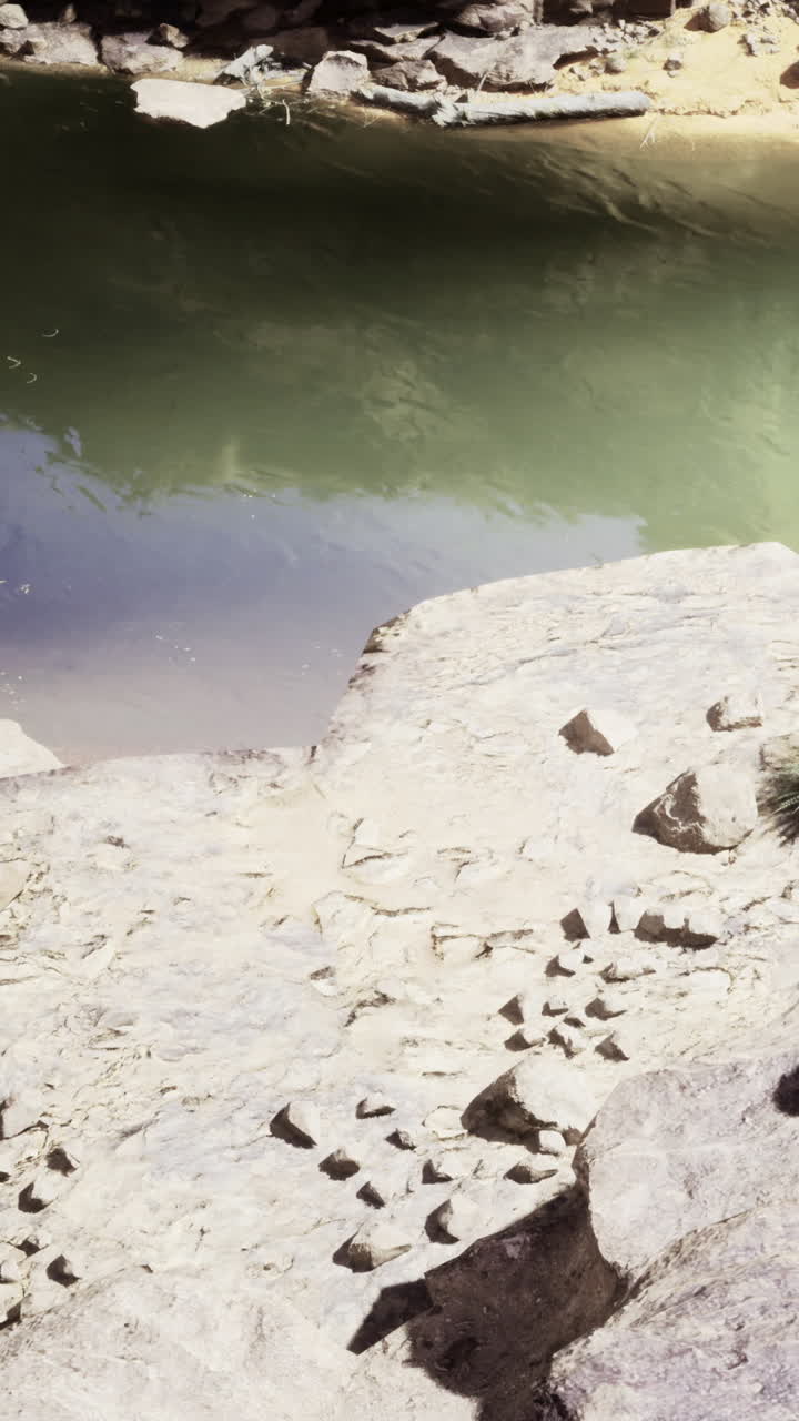 Acqua verde vivace che riflette la luce del sole tra aspre rocce naturali.