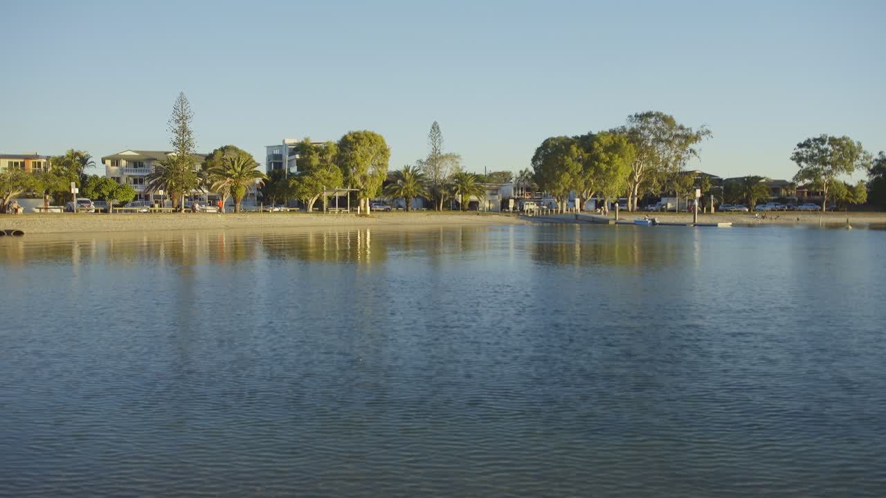 Boaters prepare for an evening outing at Tallebudgera Creek’s boat ramp, with golden light casting reflections on the calm waters.