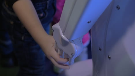 child holding robot hand friendly robotics