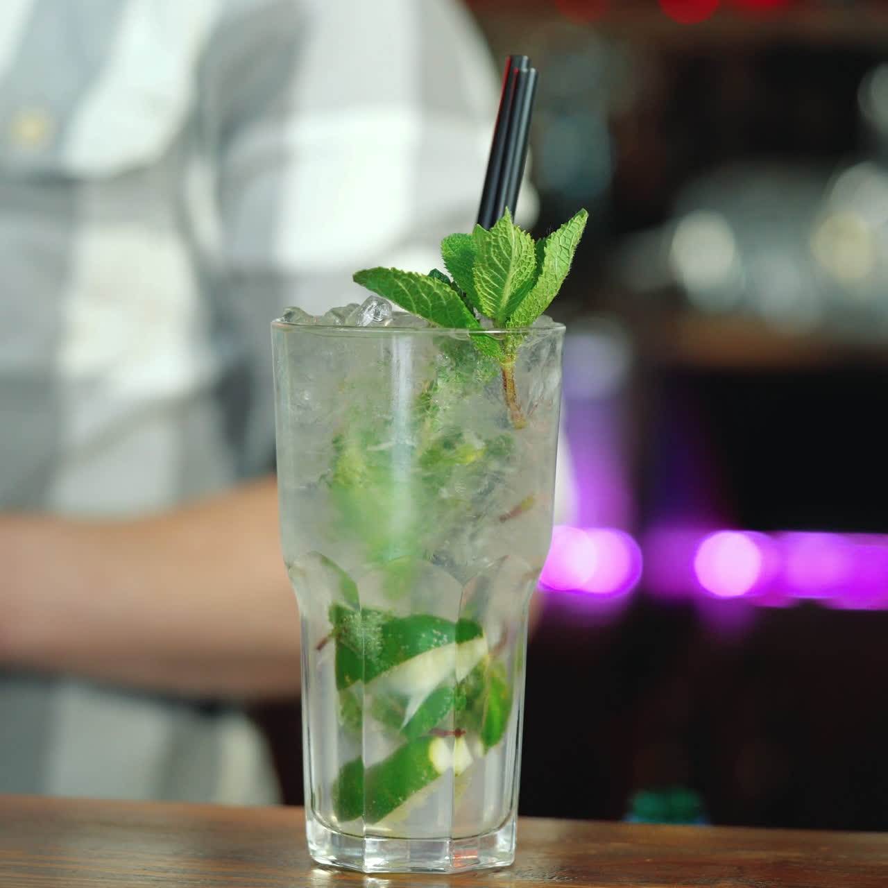 Barman decorates a ready-made cocktail with lime that stands on the bar counter Sqare video