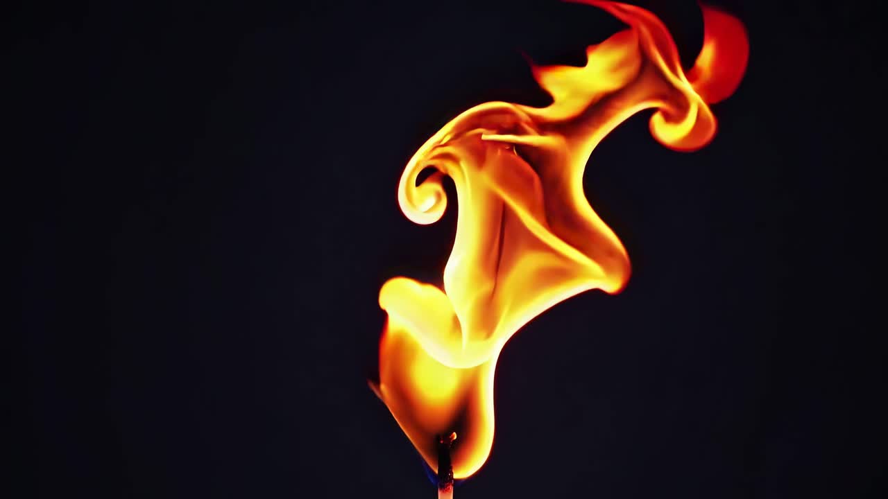 Close-up video of a single flame against a dark background, capturing the fluid motion and vibrant