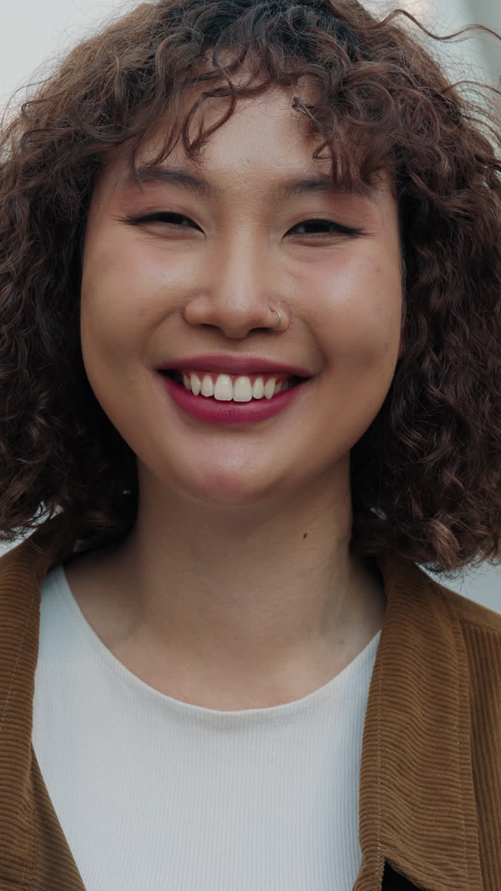 retrato de una mujer sonriente con el cabello rizado