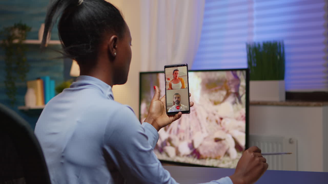 Black young lady discussing on webcam with family using smartphone