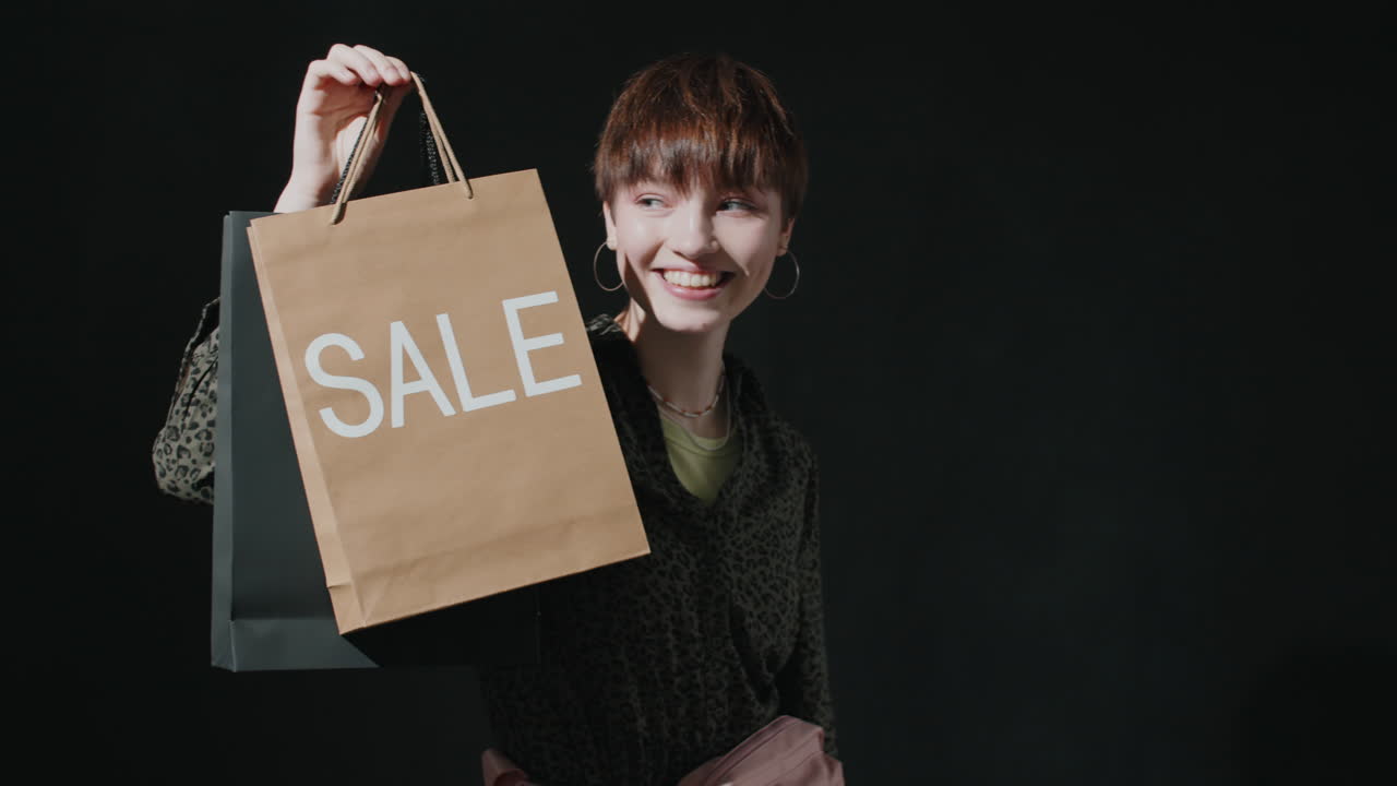 retrato de una chica bonita sosteniendo una bolsa de compras de venta y sonriendo