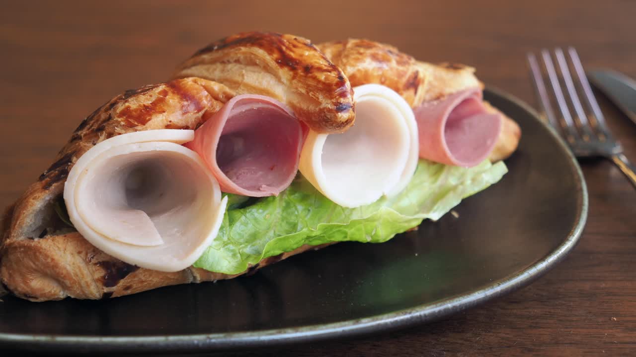 sándwich de croissant con jamón y pavo