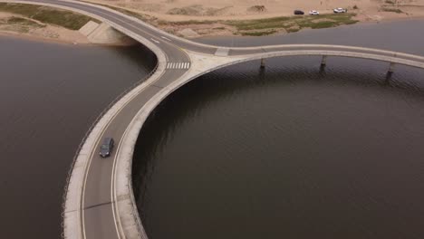 a drone follows a car on a circular bridge at laguna garzon