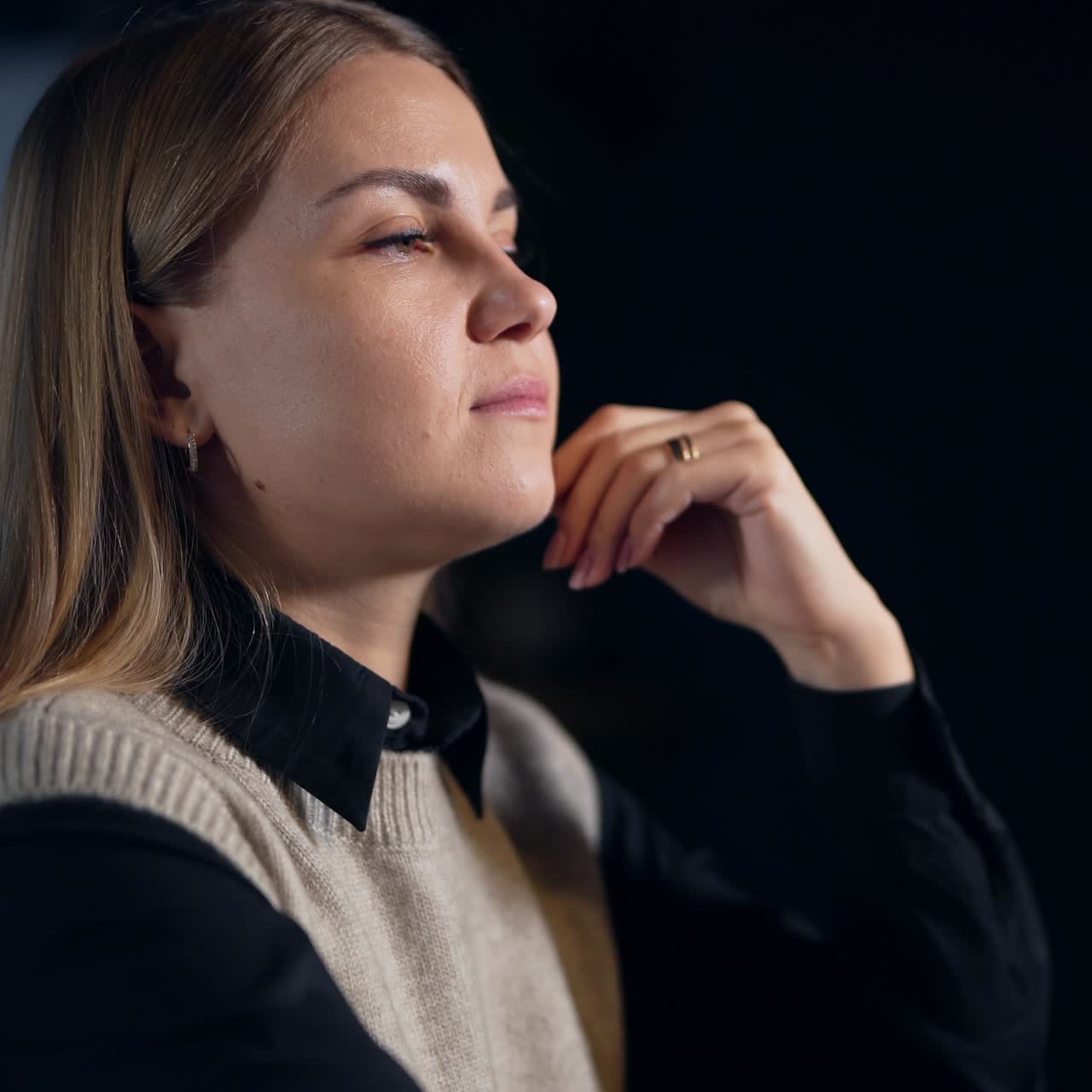 Pretty woman sitting and thinking over something. Female entrepreneur filling stressed after a long working day. Close up. Dark blurred backdrop