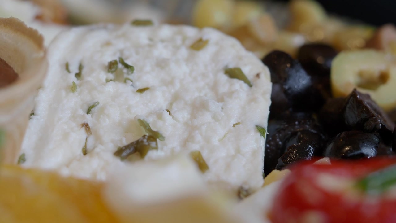 Primo piano di formaggio feta con olive su un piatto da antipasto