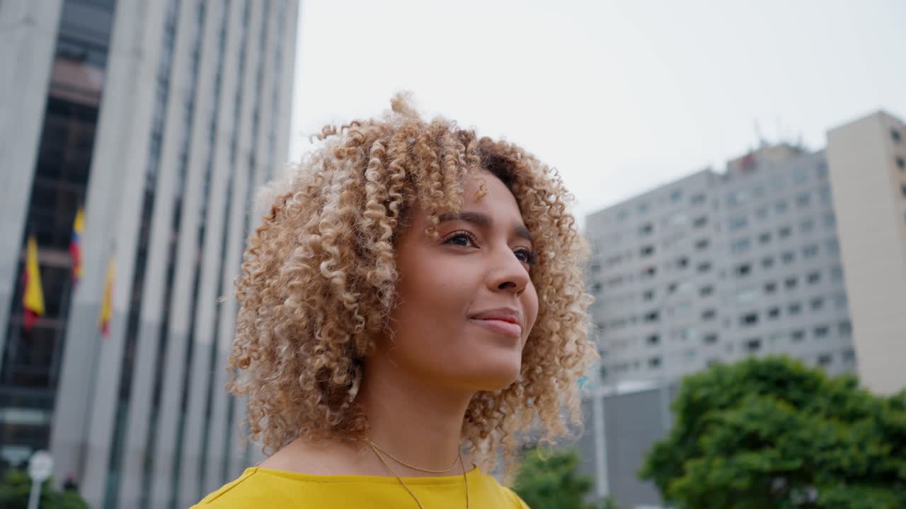 Donna che cammina a Bogotá, Colombia, con persone sullo sfondo.