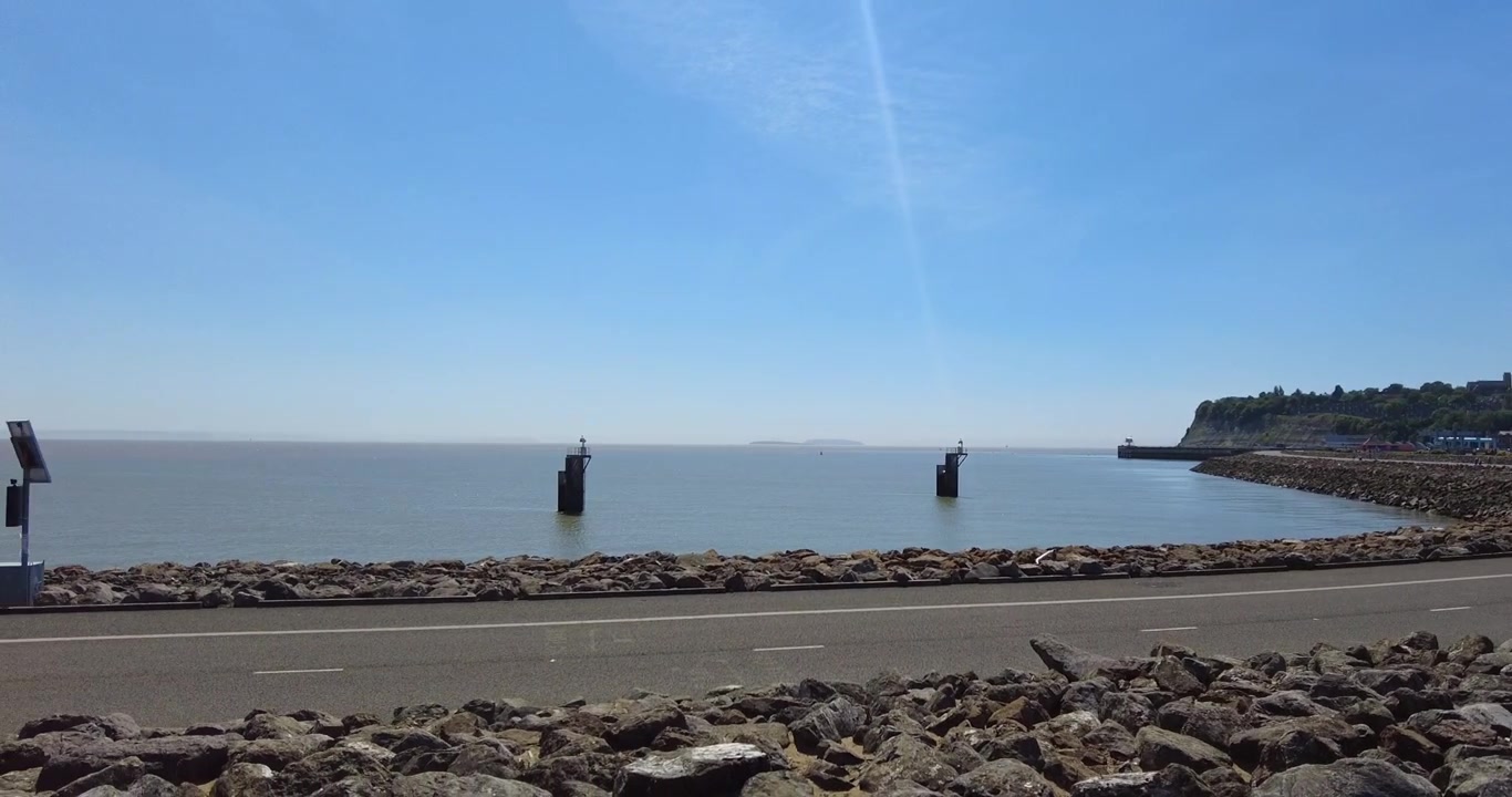 美しい晴れた日のカーディフ湾で、道と青い空を左にパンするショット