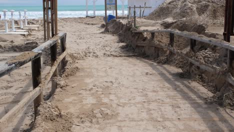 Tilt-up-view-of-damaged-sea-beach-after-a-storm-in-Los-arenales-del-sol,-near-Alicante-city,-Spain