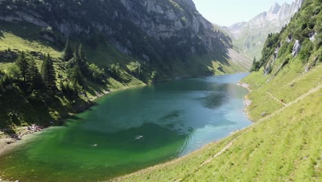 lago de montaña falensee en los alpes suizos en suiza - vista aérea de drones de personas caminando y nadando en el lago azul esmeralda