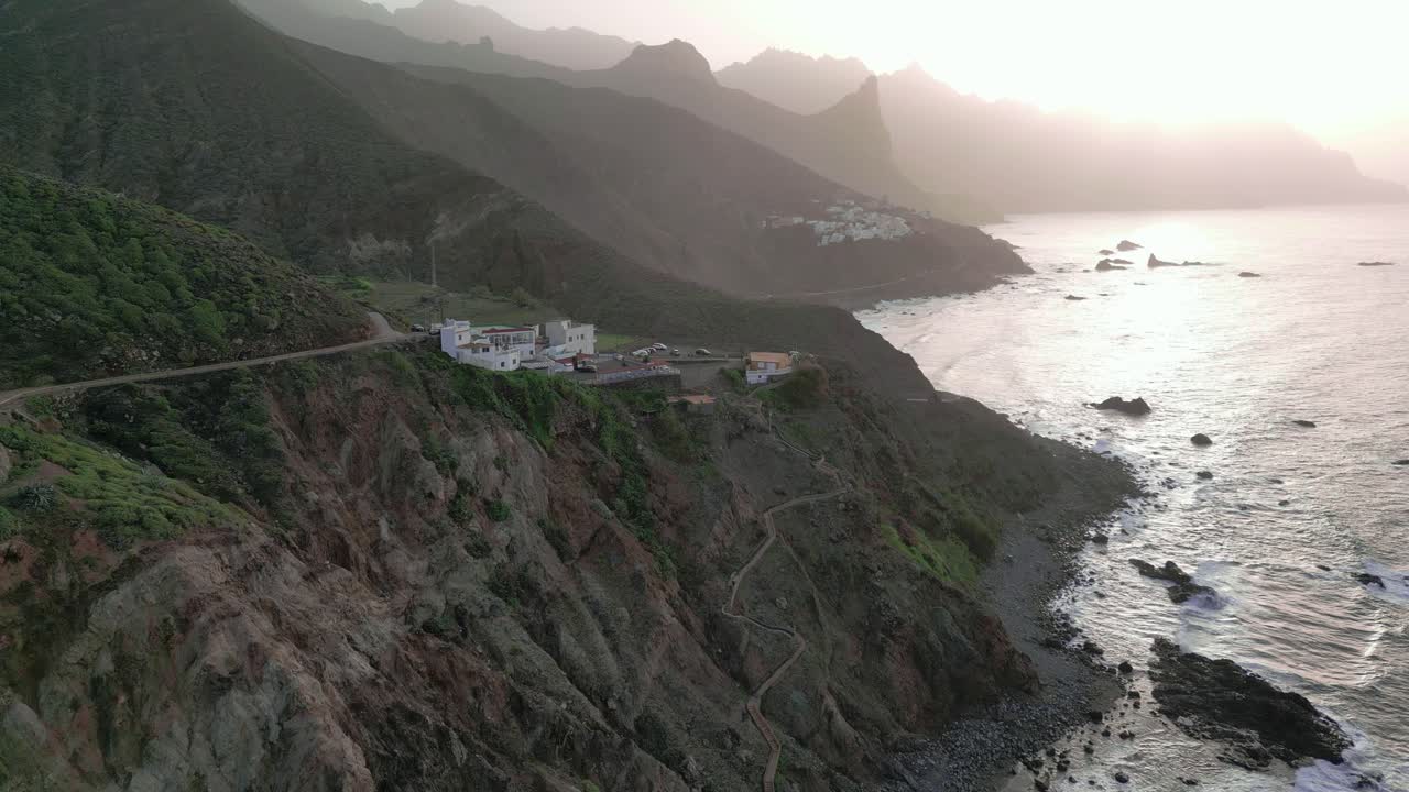 vista aérea de un pueblo costero junto a los acantilados al atardecer