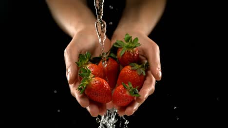 el agua se vierte en las manos con fresas frescas 4k
