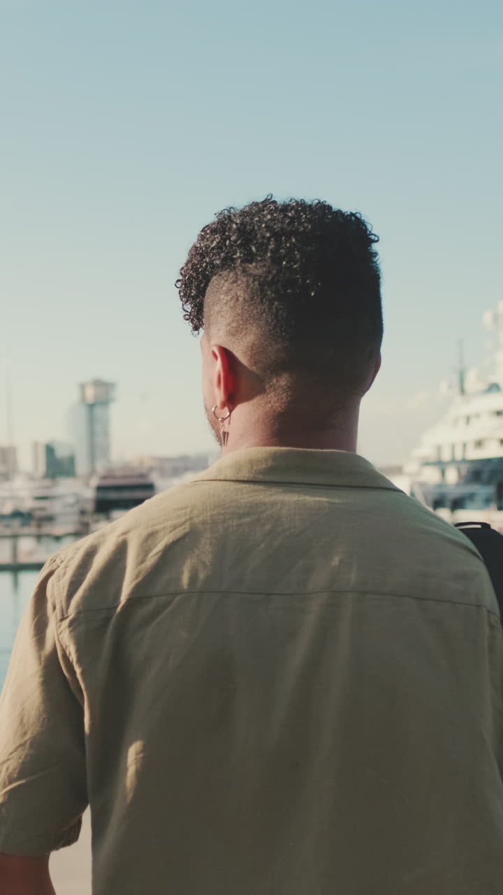 Uomo con i capelli ricci che guarda il porto