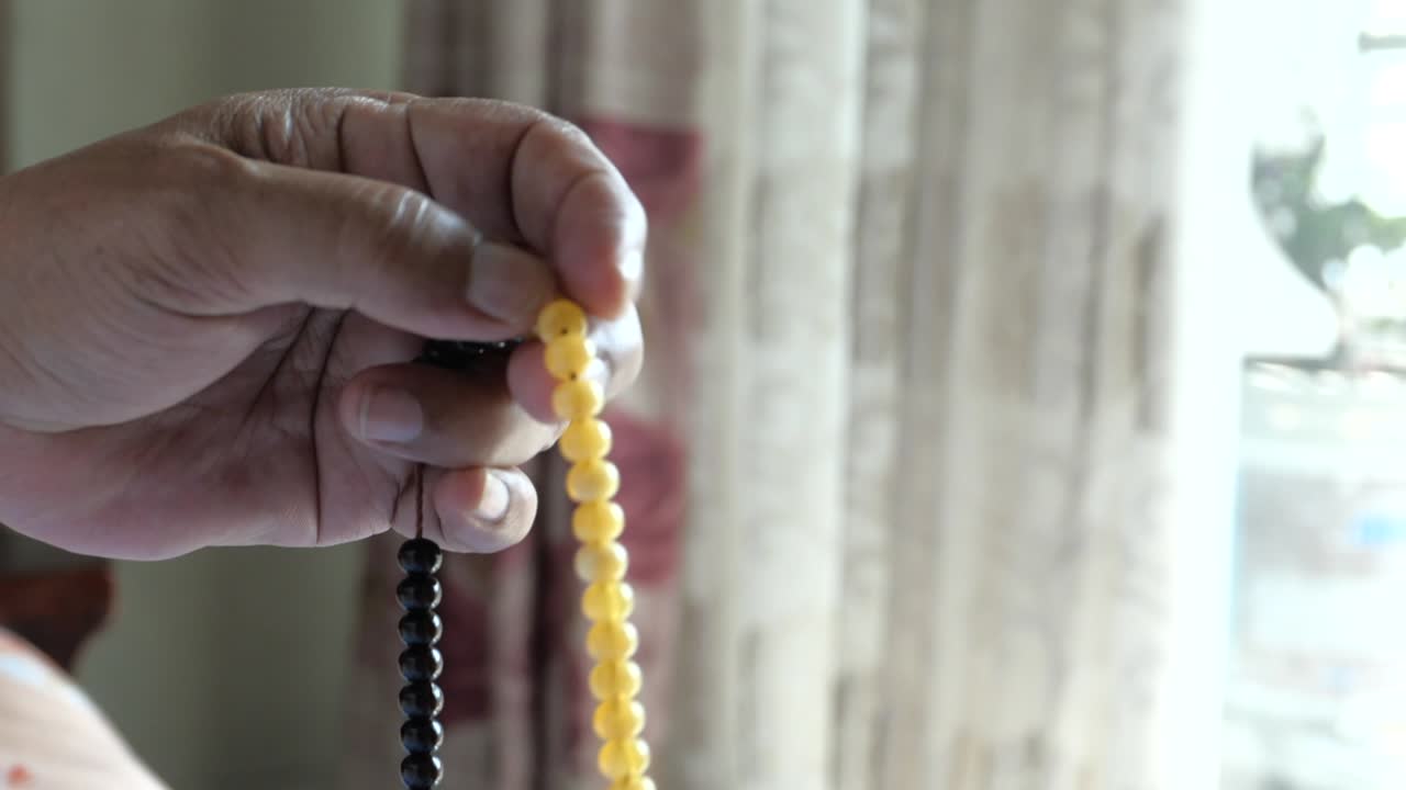 머리에 스카프를 쓰고 밤에 기도하는 무슬림 노인