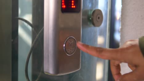 persona presionando el botón del ascensor